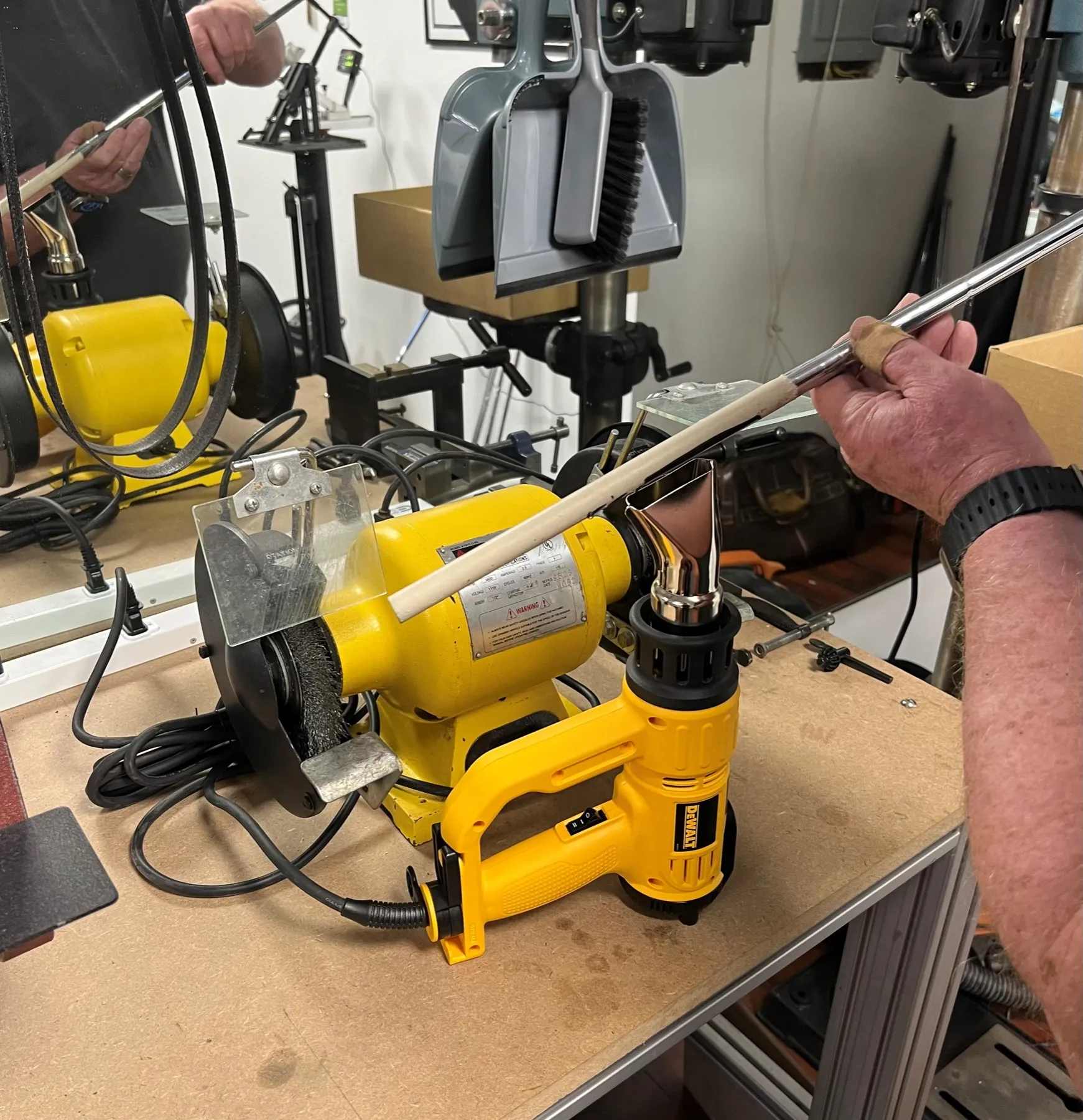 A club in the vise next to a heat gun on the bench